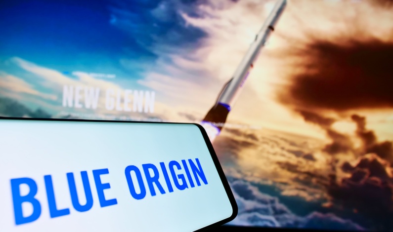 Logoul Blue Origin, compania spațială a lui Jeff Bezos, pe telefon, cu o rachetă în spate