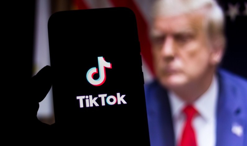 Logoul TikTok pe telefon, în fața unei poze cu Donald Trump