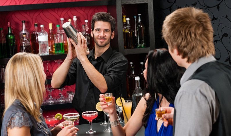 Barman care face cocktail-uri pentru un grup de prieteni