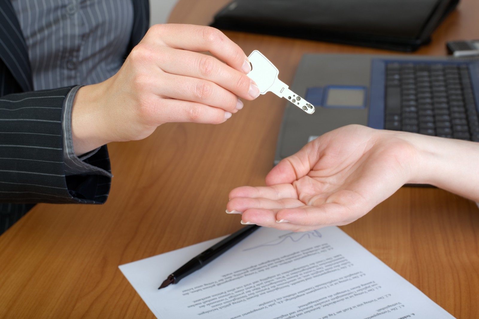 Agent imobiliar înmânează o cheie de casă unui cumpărător
